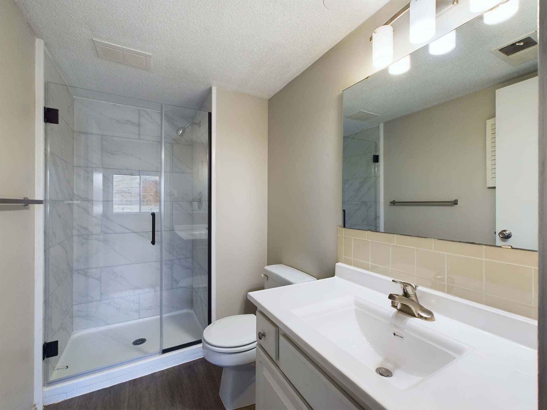 a bathroom with a shower, sink and toilet at The Edgewater