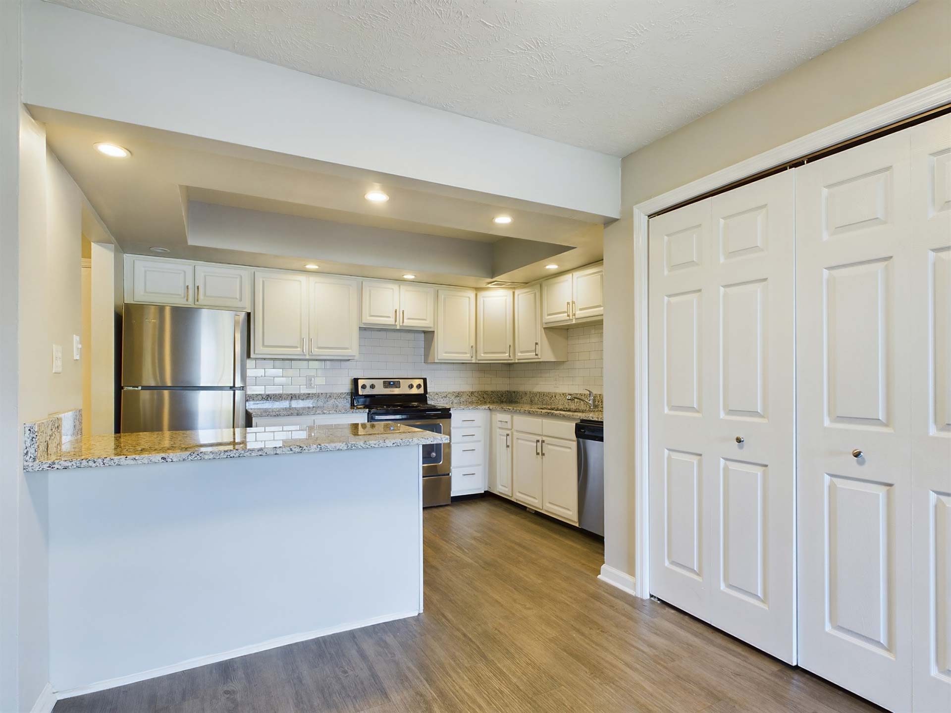 a kitchen with white cabinets and white appliances at The Edgewater